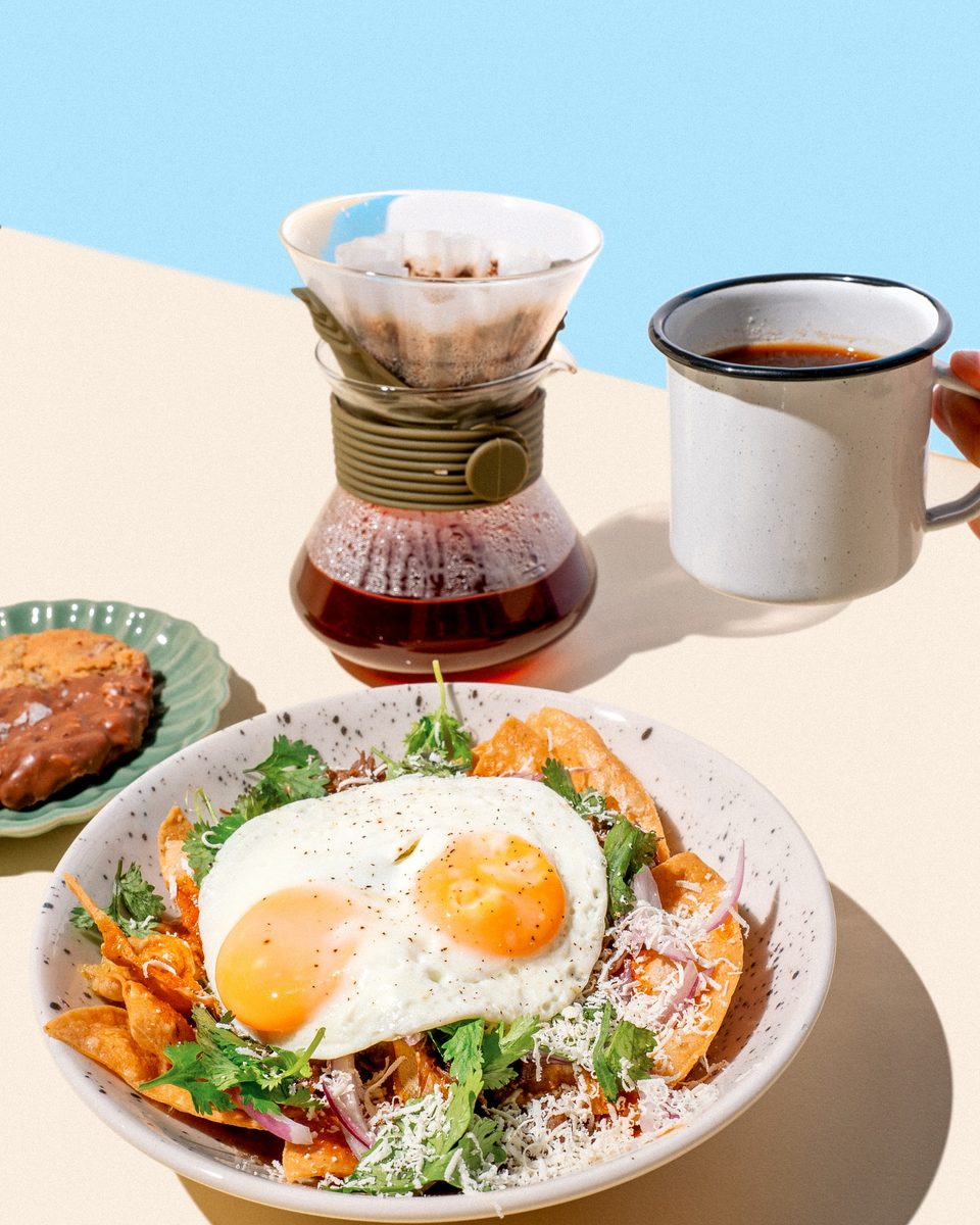 Chilaquiles con huevo, un preparador de café y una taza
